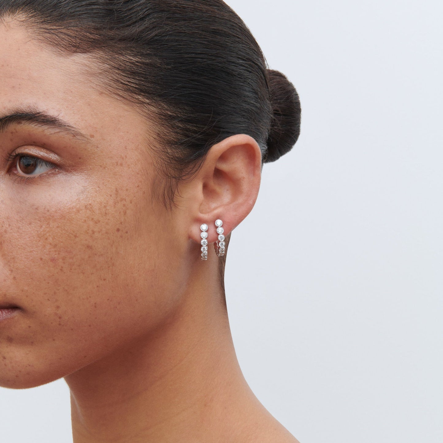 18K white gold boucle hoop earrings on woman.