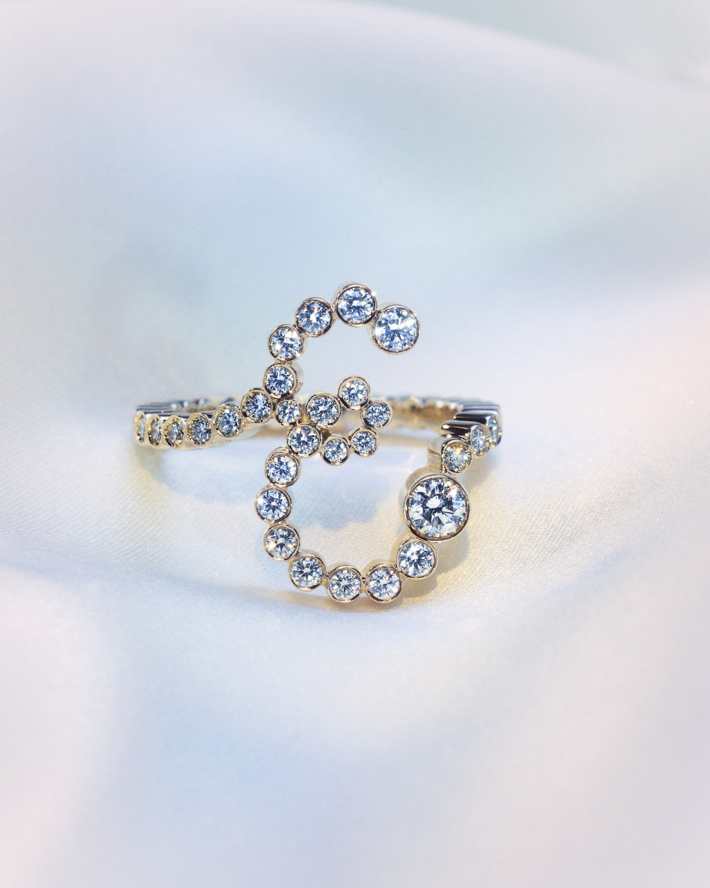 18K yellow gold diamond ring shaped as the letter 'E'.