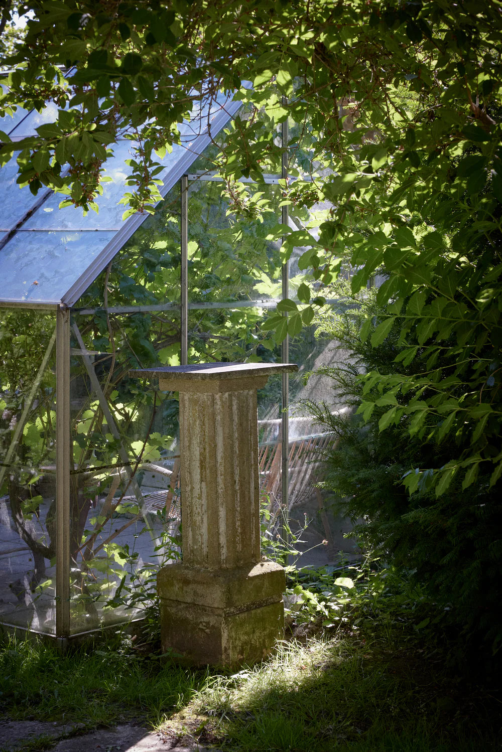 Image of a column and green house.