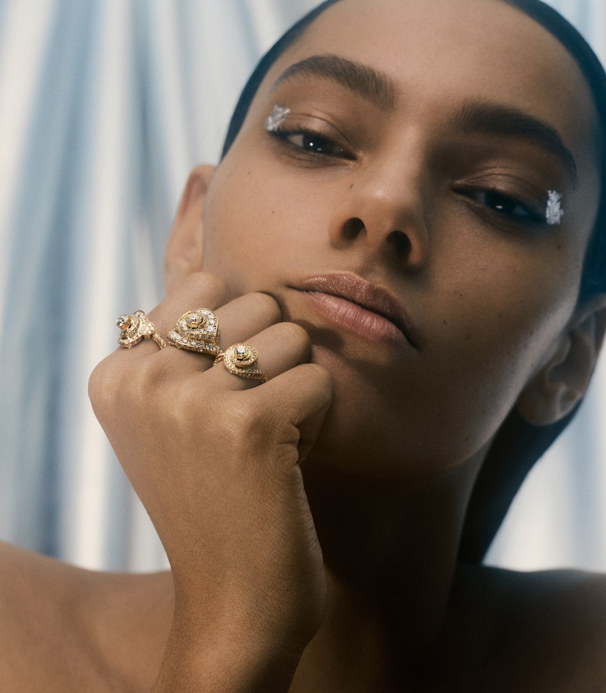 Model is wearing the Floating Kiss, Floating Heart and Floating Cloud yellow gold diamond rings stacked on one hand. 