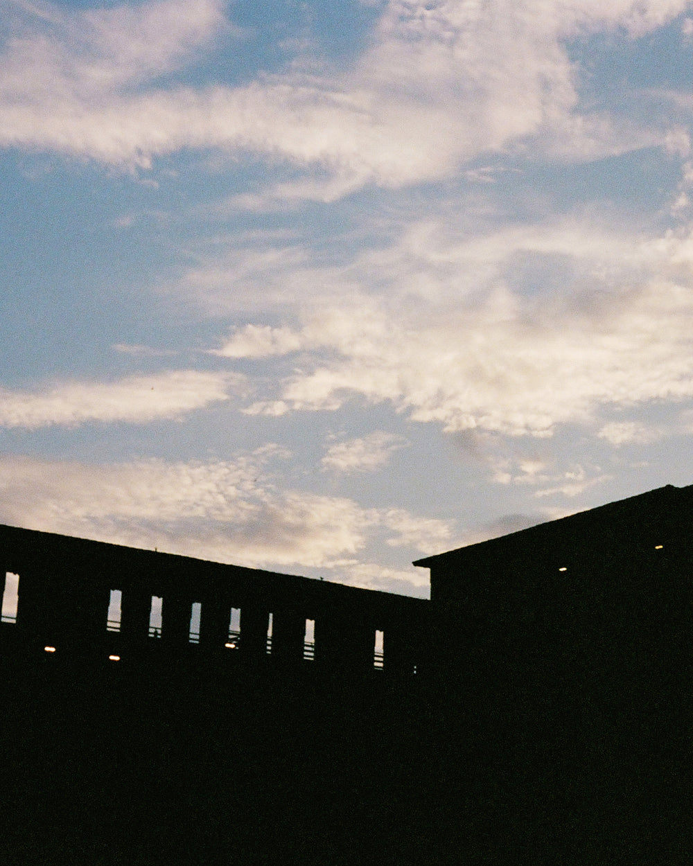Silhouette of a building against clouds in the sky.
