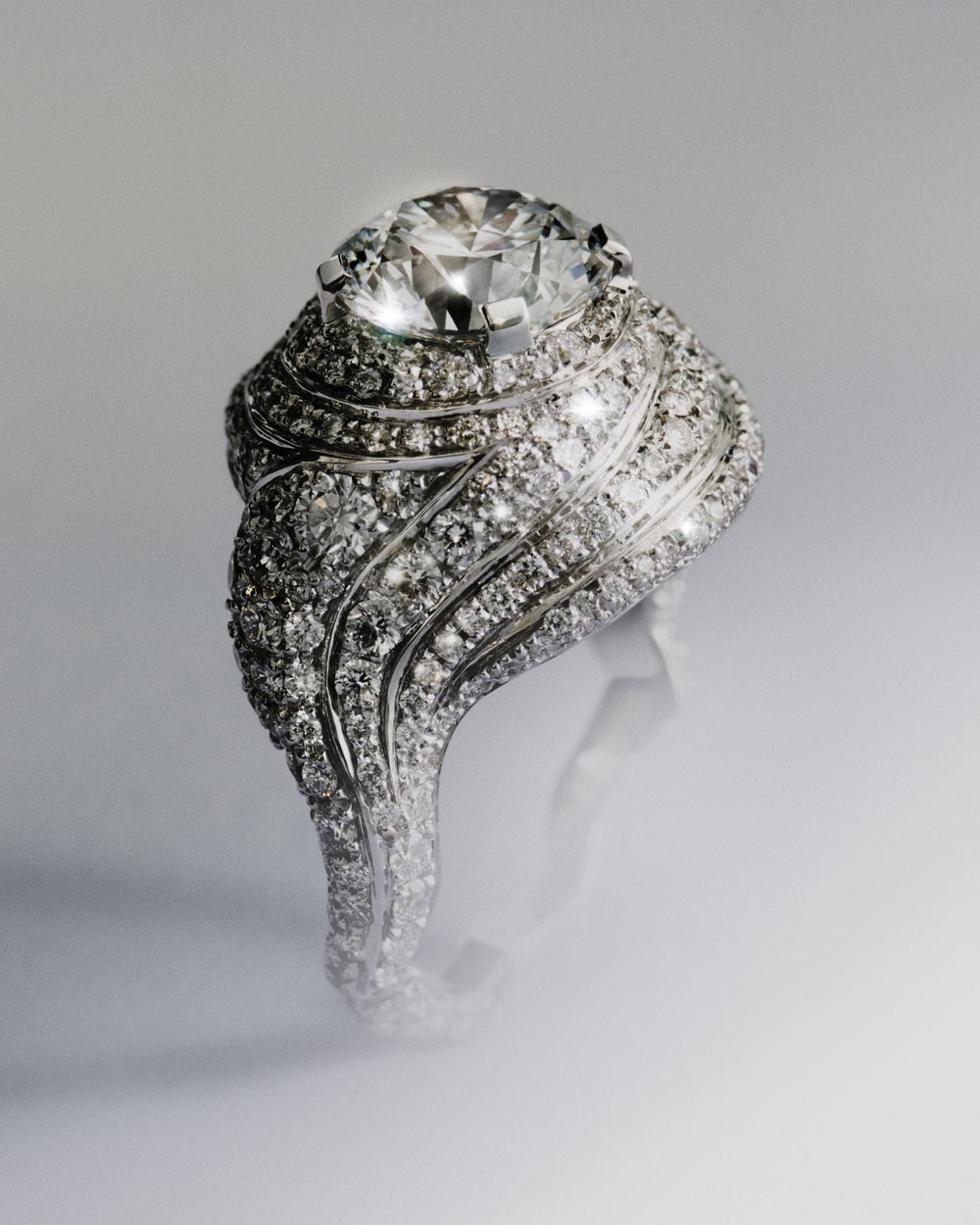 <p>Part of the trilogy of rings, the Sky 1 ring is defined by its sculptural, cloud-like form – designed to feel light despite its presence, with a soft, swelling volume reminiscent of a marshmallow. Drawing from the weightlessness found in Cy Twombly’s works, Sophie wanted to evoke the same feeling in jewellery. <br/><br/>Sky 1 is crafted in polished 18K recycled white gold and centred around a 3.02 ct round brilliant-cut diamond of E colour and VVS1 clarity, graded Triple Excellent (3X) with a Hearts & Arrows cut with 339 round pavé-set  diamonds, bringing the total carat weight to 6.07 ct.</p>