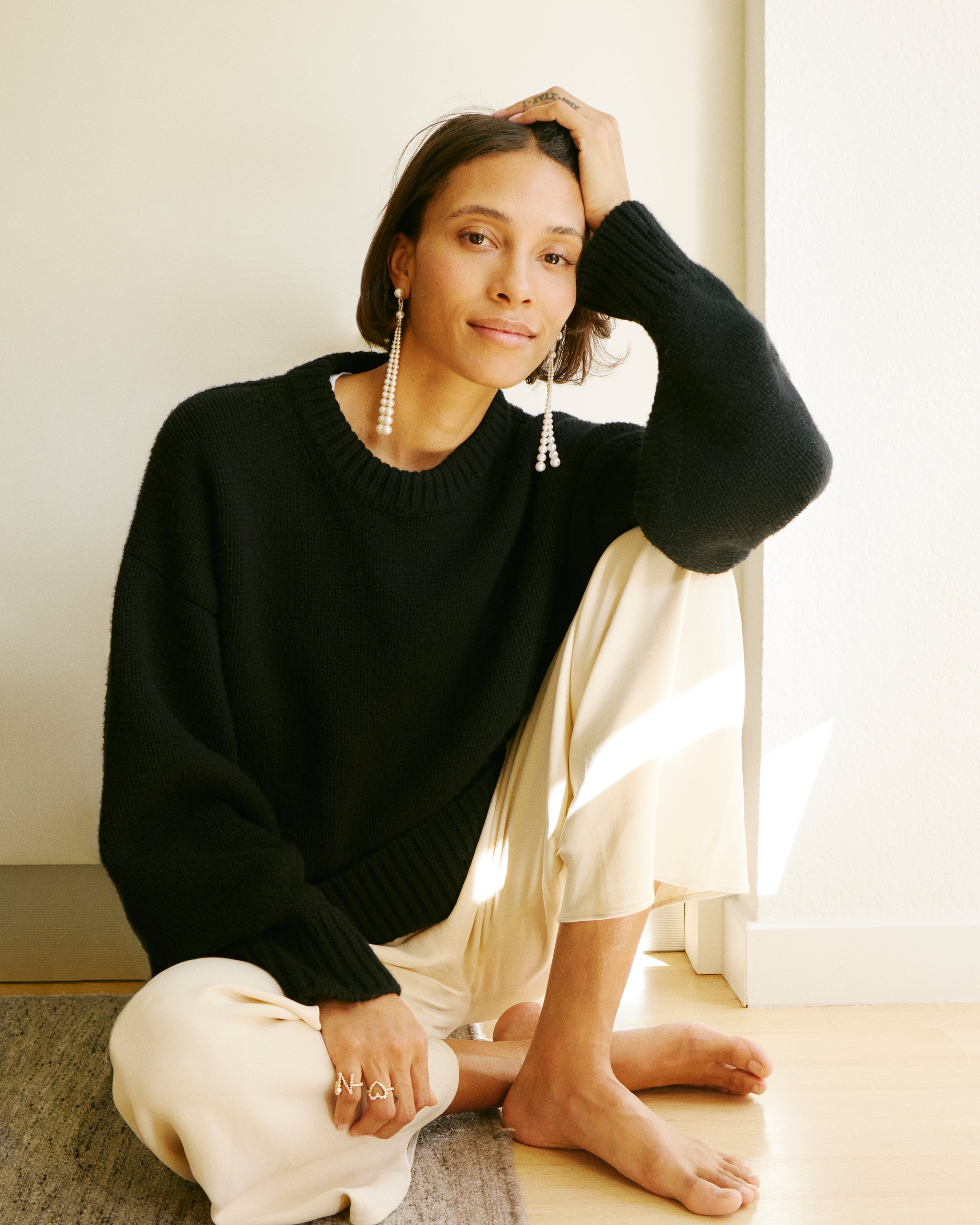 TyLynn Nguyen is wearing the Peggy Opera long pearl earrings, Ensemble Coeur diamond heart letter ring and Ensemble N diamond letter ring.