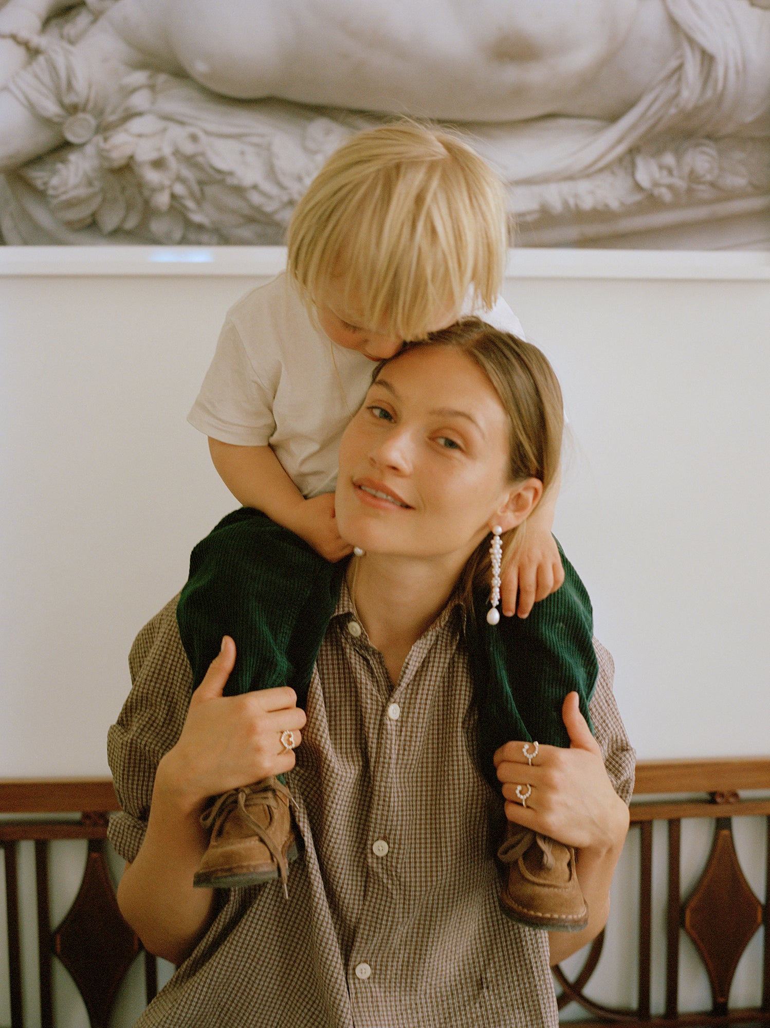 Caroline Corinth with her son, Carl. Caroline is wearing the Grand Bellis long pearl earrings, Ensemble C diamond letter ring and Ensemble Coeur diamond heart ring. Carl is wearing the Simple C diamond letter necklace.