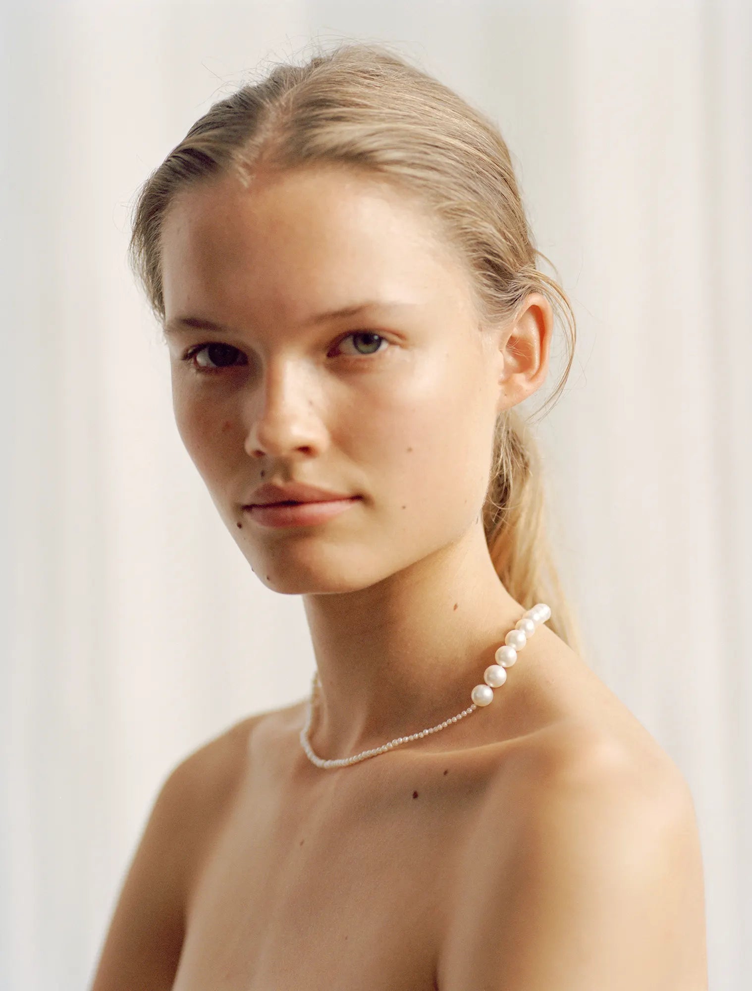 Blonde model wearing Peggy pearl necklace