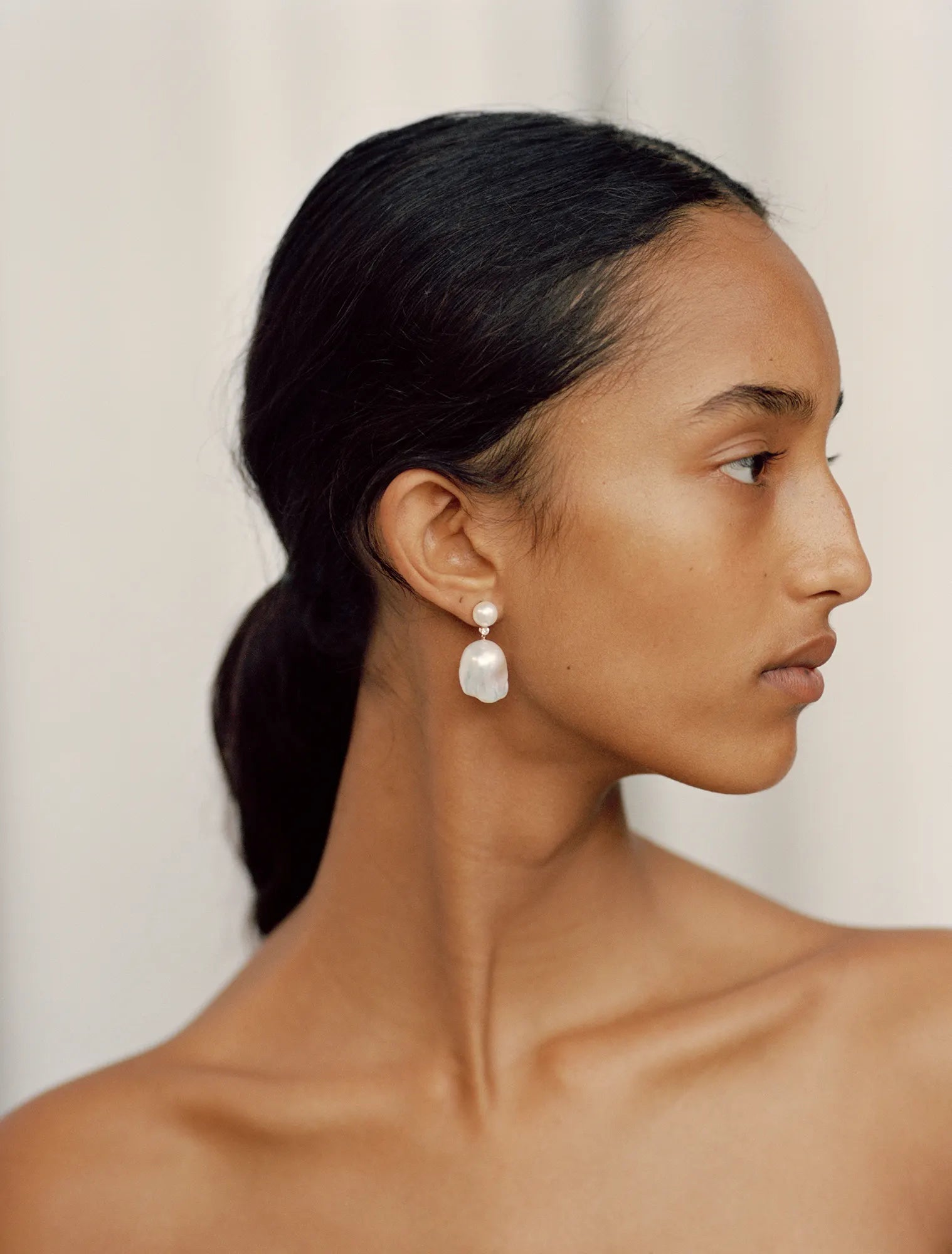 Model showing her profile while wearing Venus Diamant peal earring