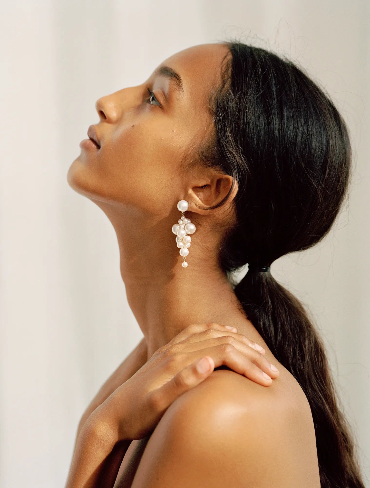 Model wearing Sienna earrings which are handmade in 14K yellow gold with freshwater pearls 
