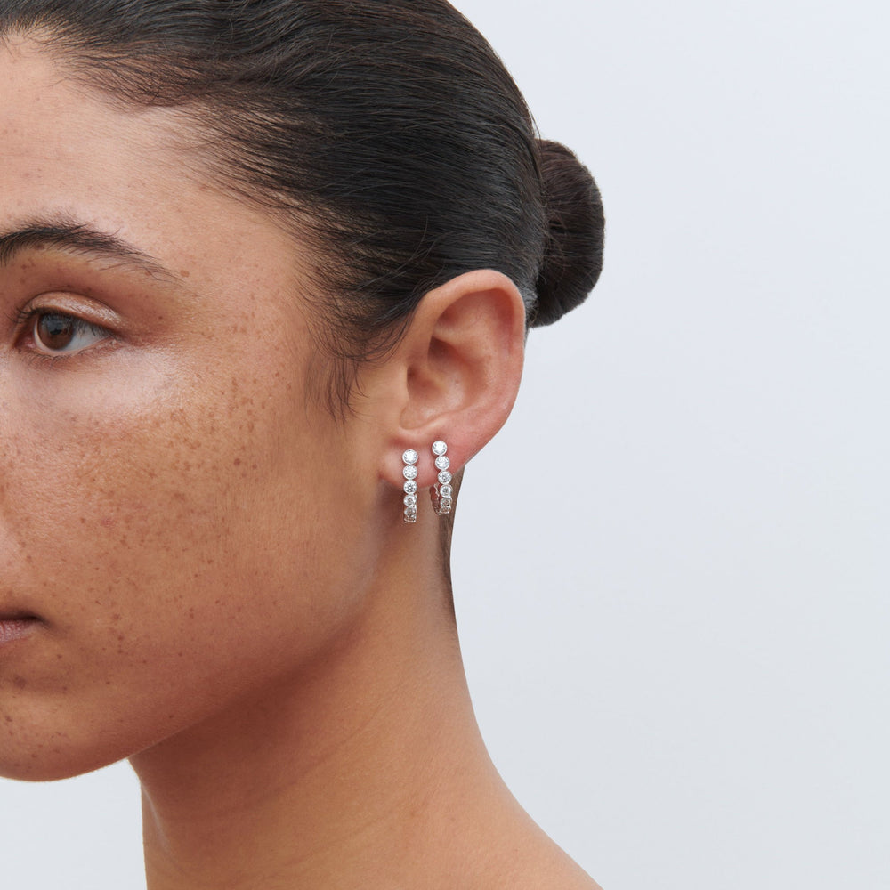 18K white gold boucle hoop earrings on woman.